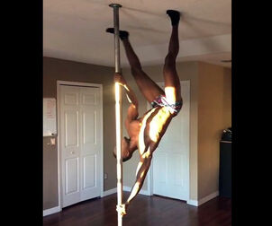 Dark-hued male stripper rolling on a pole.